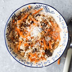 a bowl filled with carrots and granola on top of a table