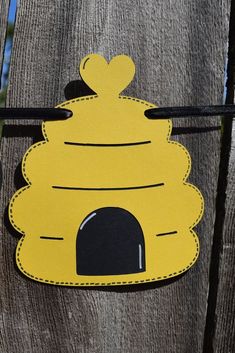 a paper cut out of a beehive hanging on a fence post with a heart