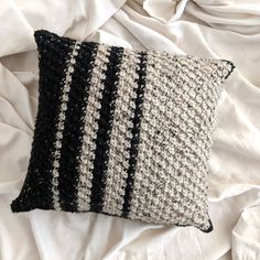 a black and white pillow sitting on top of a bed