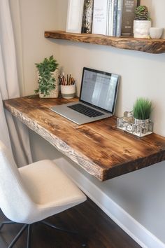 a laptop computer sitting on top of a wooden desk next to a white chair and potted plant