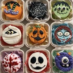 twelve decorated cupcakes in plastic containers with faces and decorations on them for halloween