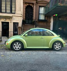 a green car parked in front of a building