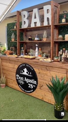 an outdoor bar is set up with potted plants and succulents on the grass