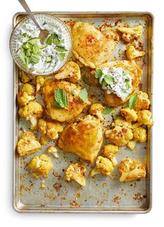 chicken and cauliflower with ranch dressing on a baking sheet