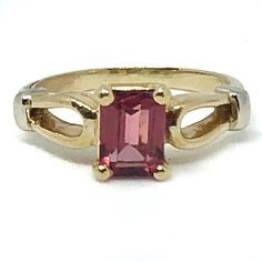 Gorgeous 14K gold and rhodolite garnet ring would make the most thoughtful and beautiful gift for someone special!  It would also be an enchanting engagement ring, with its shimmering pinkish red rosé wine colored solitaire emerald-cut stone. Shimmery & clear deep rose pink pyrope garnet, known as a rhodolite garnet, is free of visible inclusions. Finger size is 5-3/4 (could be resized within reason by a reputable jeweler).  Emerald-cut stone is about 5 x 7mm. Beautiful setting is 14 karat yellow gold with white gold shoulder accents. There is even lovely detailing on the shank.  Marked inside "585" (14kt can also be expressed as .585), it weighs 3.4 grams. This ring was purchased new in 1983 & is in wonderful vintage condition. The white heart-shaped ring box shown is NOT included. The te Garnet Ring Vintage, Pyrope Garnet, Rosé Wine, Rhodolite Garnet Ring, Garnet Gem, Pinkish Red, Diamond Solitaire Necklace, Heart Shaped Rings, Solitaire Necklaces