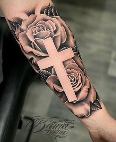 a cross and roses tattoo on the arm