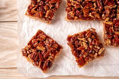 four pieces of pecan bar sitting on top of paper