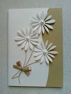 a card with white flowers and ribbon on it