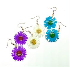 Handmade earrings made with love and care! They are an excellent addition to any wardrobe for a simple yet elegant look. 🌸 One pair of resin earrings with a delicate pressed daisy 🌸 Materials: Pressed daisy flower & Resin Your jewelry is handcrafted, making each perfectly unique and beautiful just like you!   For each purchase, $2 will go towards funding my organization: MAUA Women's Foundation that aims to provide sustainable feminine hygiene products to girls in rural Kenya, Africa. Facebook page: https://www.facebook.co/MAUAWomensFoundation Care: Remove your jewelry when in contact with water or liquids such as perfume or lotion. Store your beautiful resin jewelry in a cool dark place and out of direct sunlight to maintain the vibrant colors. Resin Flower Earrings With Flower Charm, Flower Charm Resin Earrings, Resin Flower Charm Earrings, Resin Earrings With Flower Charm, Feminine Hygiene Products, Real Flower Earrings, Pressed Flower Earrings, Hygiene Products, Flower Resin