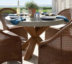 an outdoor table with chairs and plates on it