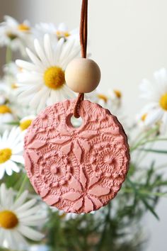 a close up of a flower vase with daisies in it and a tag hanging from the front