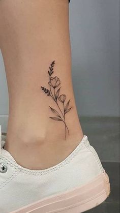 a small flower tattoo on the side of a woman's lower back ribcage