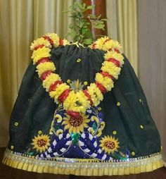 a dress made out of sunflowers is sitting on a table next to a potted plant