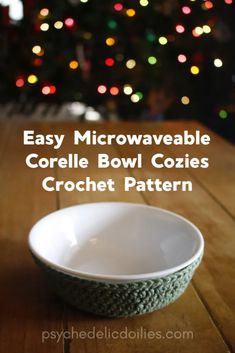 a bowl sitting on top of a wooden table next to a christmas tree with lights in the background