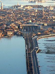 an aerial view of a large bridge spanning the width of a city across a body of water