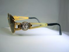 "An intoxicating amalgam of original atypical design and top optical technology, produced by prestigious yet elusive \"Castellani-Italy \", a genuine Gold Bonanza, much sought after by collectors and wearers alike. Produced in the 1990's by legendary designer Danilo Castellani-Italy, a rare if not unique pair of sunspecs. Hand made generously Gold plated metal alloy frame, sumptuously embellished with Platinum plated sculptural Egyptian motifs (King Tut's head), complemented with jet black aceta Vintage Gold Sunglasses For Formal Occasion, Gold Retro Sunglasses With Mirrored Lenses, Retro Gold Sunglasses With Mirrored Lenses, Vintage Gold Sunglasses With Gradient Lenses, Gold Metal Sunglasses With Gradient Lenses, Modern Gold Metal Sunglasses, Vintage Gold Sunglasses With Metal Frame, Vintage Metal Sunglasses With Gradient Lenses, Retro Gold Metal Sunglasses