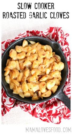 slow cooker roasted garlic cloves in a cast iron skillet on a red and white cloth