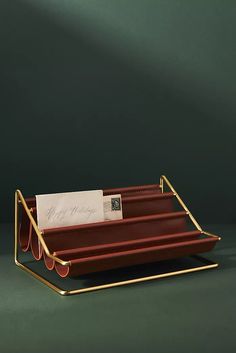 three red trays with gold handles holding cards