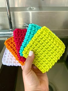 four crocheted dishcloths are sitting on top of a sink in front of a faucet