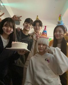 a group of people standing around each other holding a cake