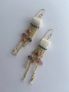 These gold wire wrapped earrings feature natural pink rose quartz chips and balls on gold plated ear wires.  The drop is approximately 3.75" in length. Gold Drop Earrings With Natural Stones, Gold Dangle Beaded Earrings With Natural Stones, Bohemian 14k Gold-filled Beaded Earrings, 14k Gold-filled Beaded Dangle Earrings, Pink Bohemian Gemstone Earrings, Gold Wire Wrapped Earrings, Bohemian 14k Gold-filled Beaded Dangle Earrings, Pink 14k Gold-filled Wire Wrapped Earrings, Long Statement Earrings