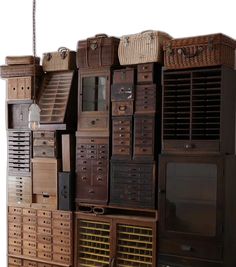 a bunch of old wooden drawers with baskets on top and bottom, all stacked next to each other