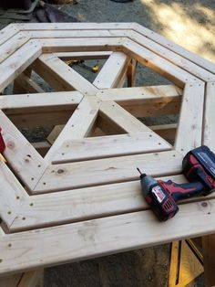 two tools are sitting on top of a wooden table that's being built into a hexagonal structure