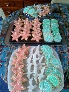 three trays filled with decorated cookies on top of a table