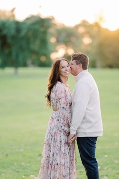 a man and woman standing next to each other in the grass