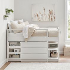 a bedroom with a bed, desk and storage drawers in the bottom bunk beds area