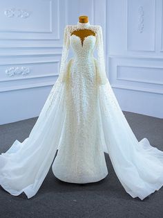 a white wedding dress with long sleeves on display