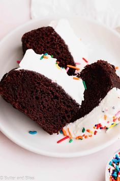 two slices of chocolate cake with white frosting and sprinkles on a plate