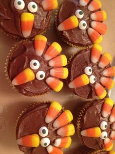 cupcakes with chocolate frosting decorated like turkeys and candy eyes on top