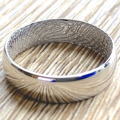 a silver ring sitting on top of a wooden table