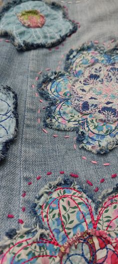 an embroidered piece of cloth with flowers and hearts on the side, sitting on top of a table