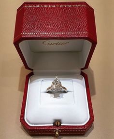 a diamond ring in a red box with the lid open to show it's inside