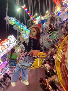 a woman is standing on a swing at an amusement park