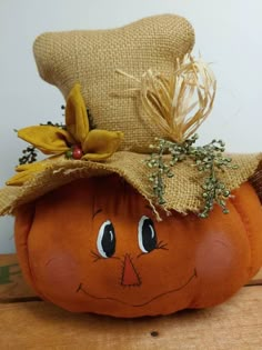 an orange pumpkin with a hat on it's head sitting on a wooden table