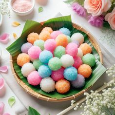 a basket filled with lots of different colored candies on top of a white table