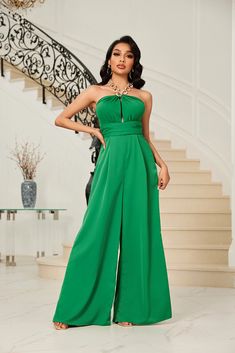 Halter neck solid jumpsuit with open detailing in the front, open back with tie string and chain strap. Fitted waist and wide leg bottom. Solid Color Strapless Wide Leg Jumpsuit For Party, Elegant Green Backless Jumpsuits And Rompers, Elegant Green Backless Jumpsuit, Backless Strapless Jumpsuit For Summer Formal, Summer Formal Backless Strapless Jumpsuit, Green Wide Leg Jumpsuits For Party, Green Wide Leg Jumpsuits And Rompers For Party, Green Wide-leg Jumpsuits For Party, Elegant Green Strapless Jumpsuit For Night Out