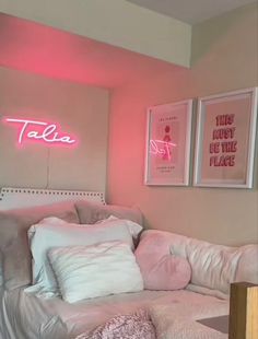 a bedroom with pink walls and white bedding in the corner is lit up by neon lights