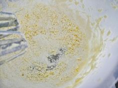 a mixing bowl filled with batter and whisked with flour next to a metal beater