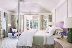 a bedroom with white walls and green curtains on the windowsills, along with a canopy bed