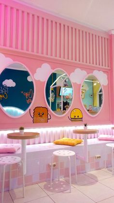 the inside of a restaurant with pink walls and round mirrors