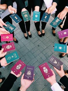 many people are holding their passport in the middle of a circle