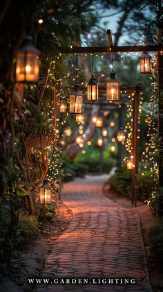 an outdoor path with lanterns and lights hanging from the trees on either side is a brick pathway that leads to a pergolated walkway