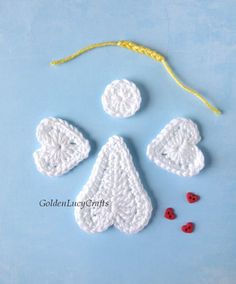 crochet angel ornament with red buttons and yellow string on blue background