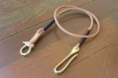 a pair of scissors sitting on top of a wooden floor next to a corded leash