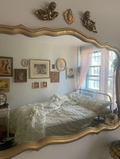 a bedroom with a large mirror on the wall and pictures on the wall above it