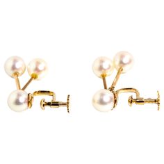 Crafted in 14 carat yellow gold, these elegant vintage clip-on earrings each feature a high luster round cultured pearl attached to a stud clip and two additional pearls suspended on gold bars. The Kiera Earrings are elegant and quietly beautiful, perfect for every day and any occasion and bestowing the wearer with a touch of panache. The Kiera Earrings Gem Details The round white cultured pearls have very high luster, are well matched, and measure approximately 7.00 millimeters. Size The drop o